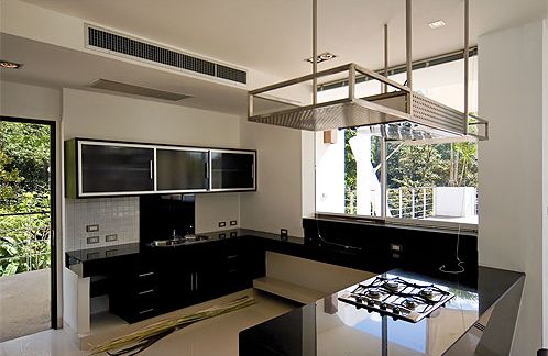 The open plan kitchen features a central island with hob and extractor